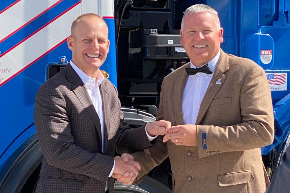 Republic Services President and CEO Jon Vander Ark, left, presents Frank Epps with a new collection truck in honor of the award.